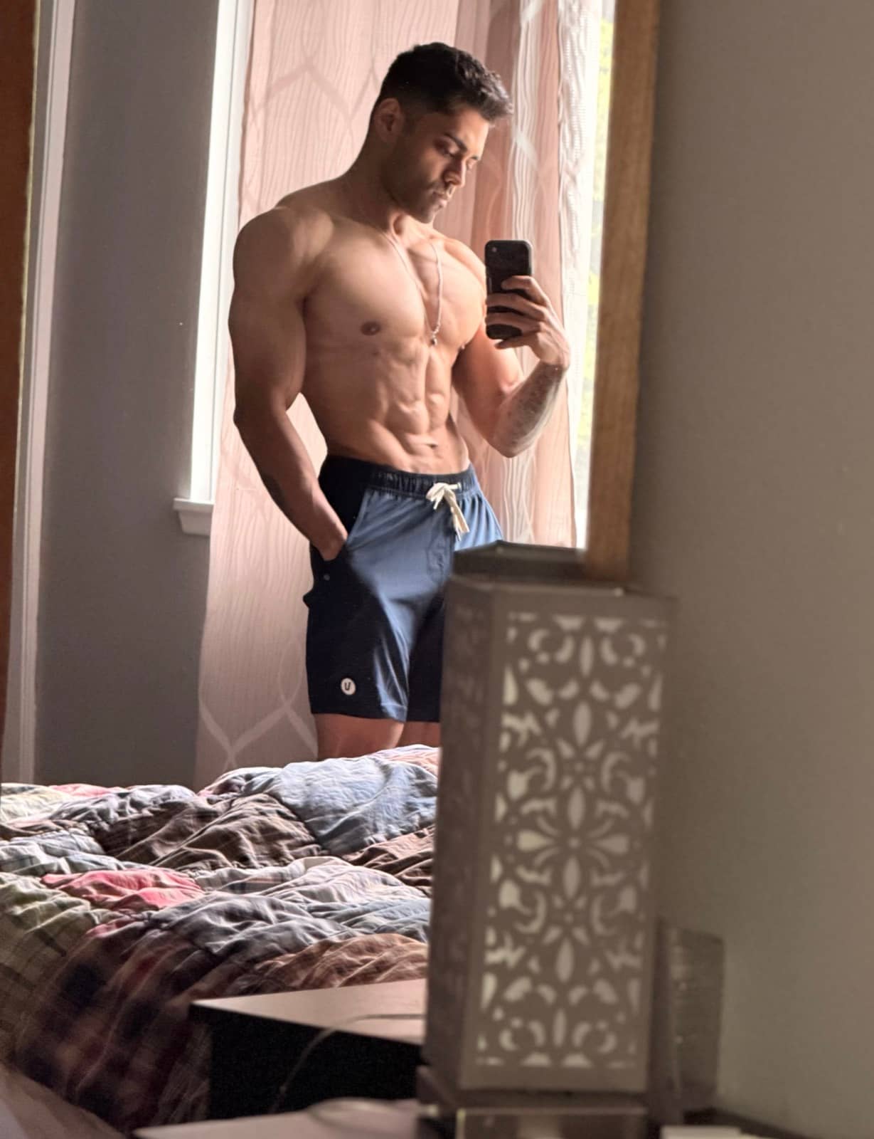 Abe Seth in a lean mirror check-in photo near a window.